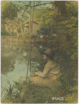 Femme assise près d'un cours d'eau